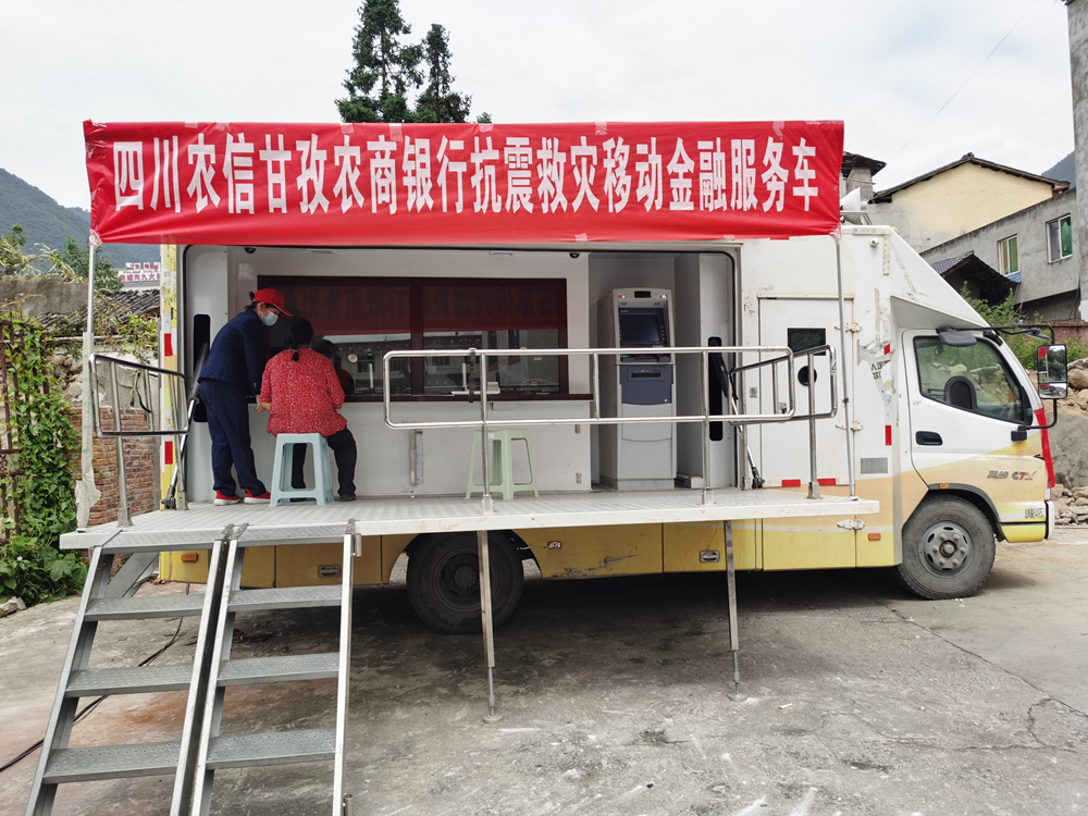 四川農信甘孜農商銀行抗震救災流動服務車進駐災區(qū)辦理金融業(yè)務.png