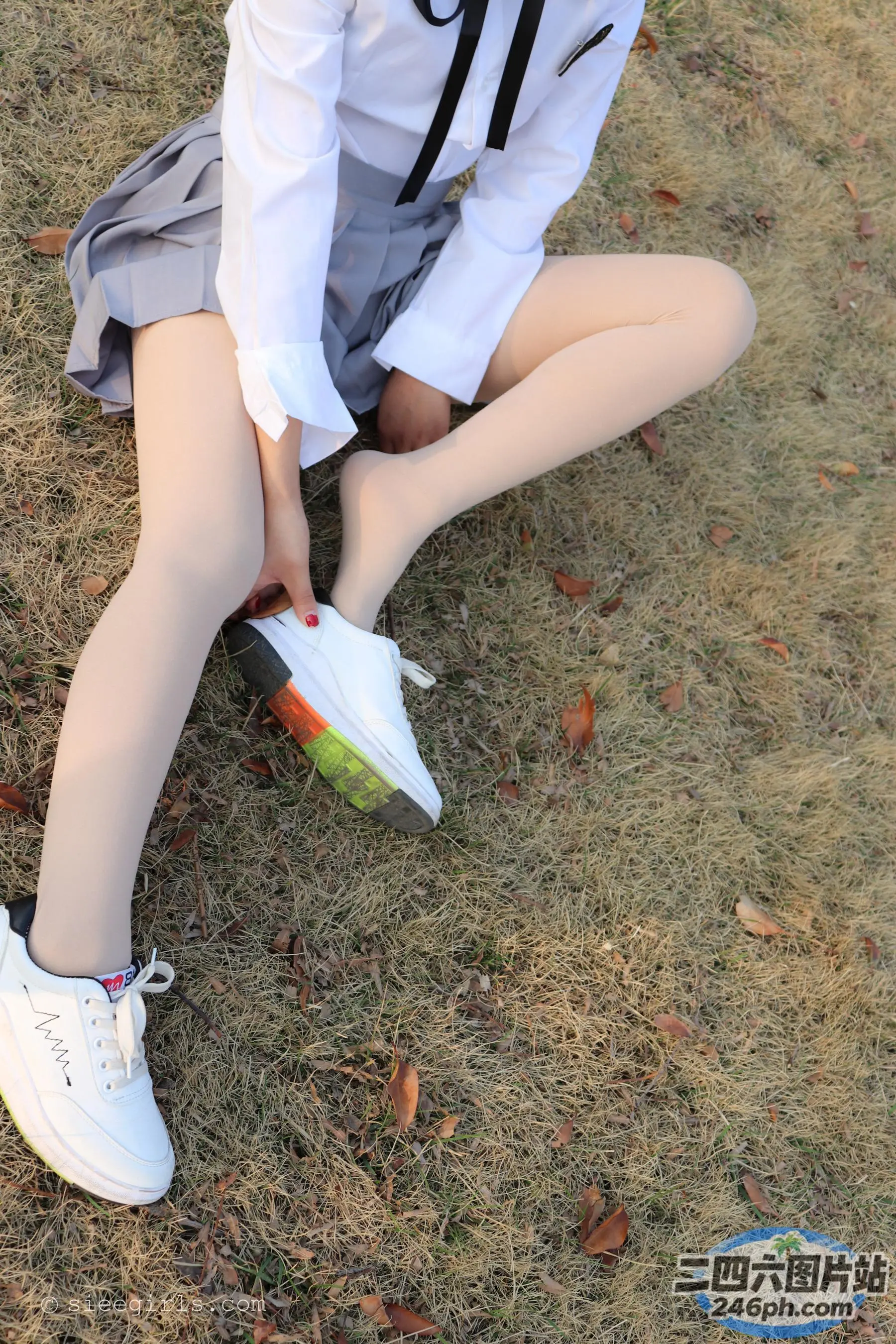 有一个女人坐在地上，双腿交叉