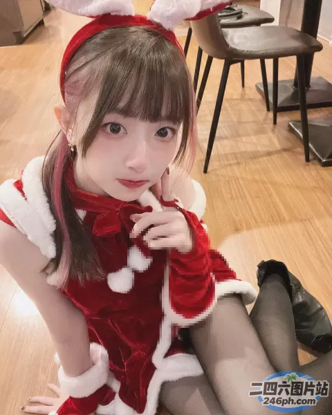 地板上坐着一个穿着圣诞老人装的女孩