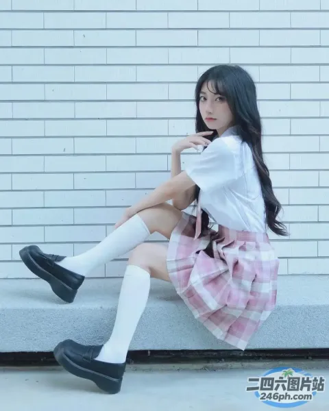 穿着粉红色格子裙坐在台阶上的 arafed 亚洲女孩
