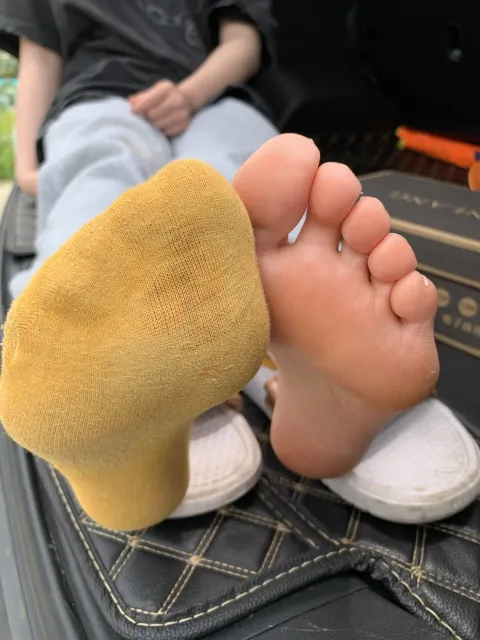 有人坐在行李箱上，双脚撑起