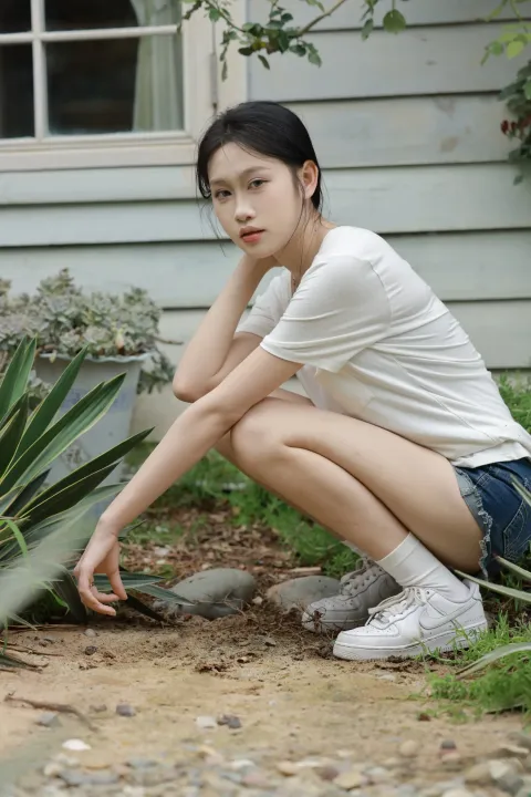 阿拉夫德女人蹲在一栋种有植物的房子前
