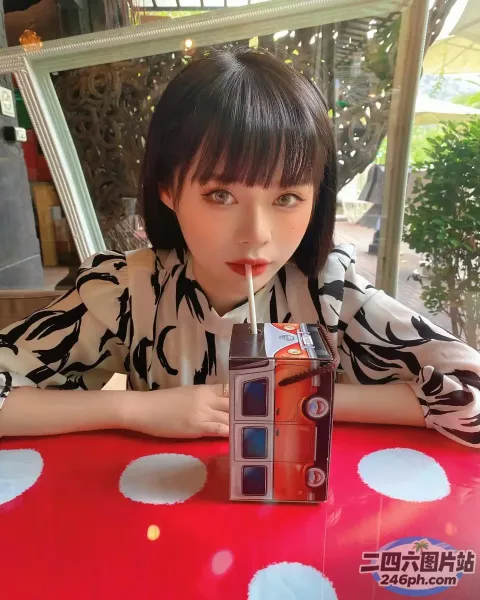 坐在桌子旁的女人，塑料杯里放着饮料