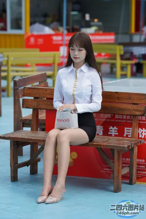 阿拉菲女人拿着一个包和一个钱包坐在长凳上