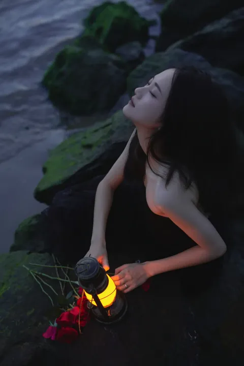 阿拉夫德女人坐在岩石上，手里提着灯笼