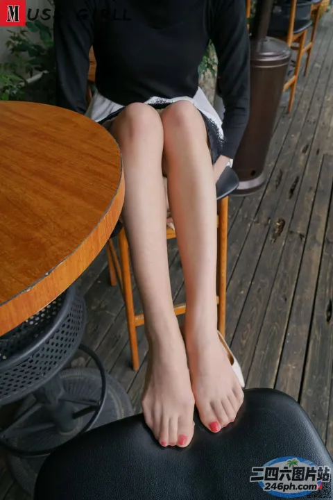有个女人坐在椅子上，脚放在桌子上