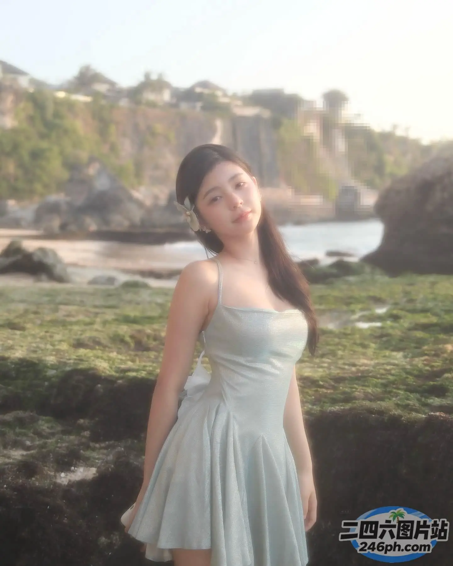 有一个女人穿着裙子站在岩石海滩上