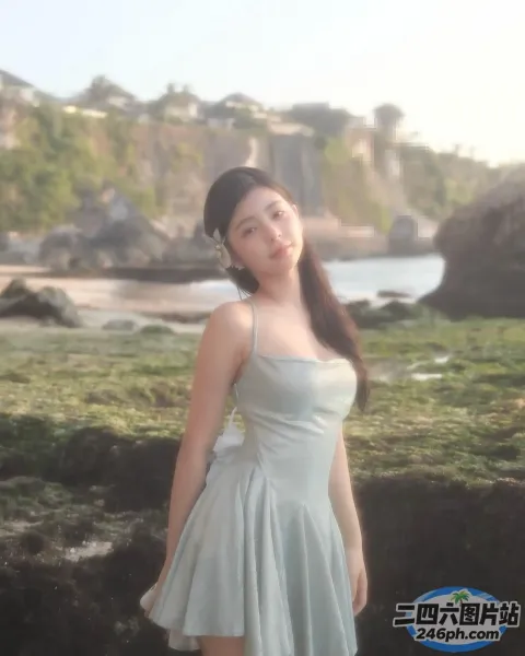 有一个女人穿着裙子站在岩石海滩上