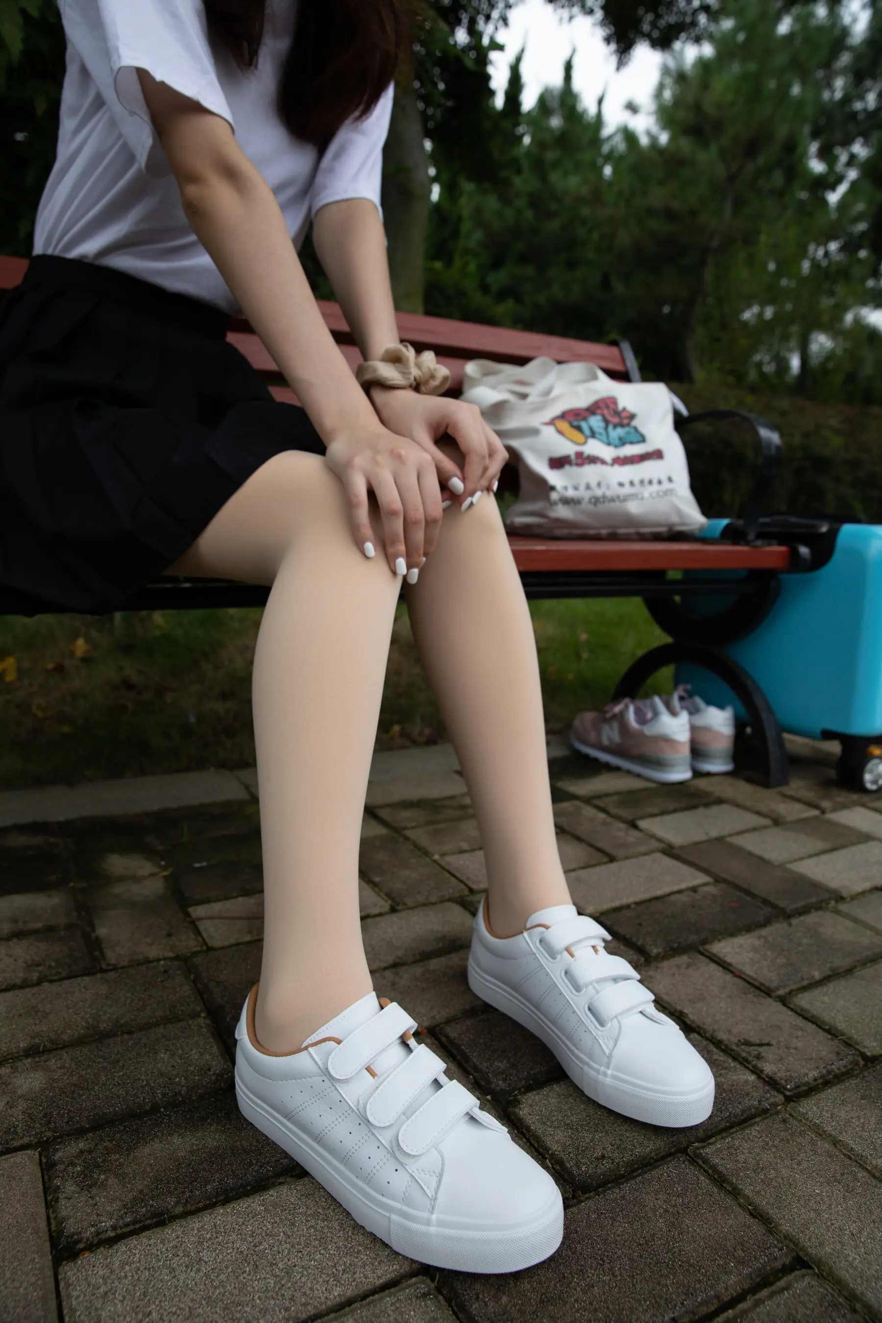 有个女人坐在长凳上，双腿交叉