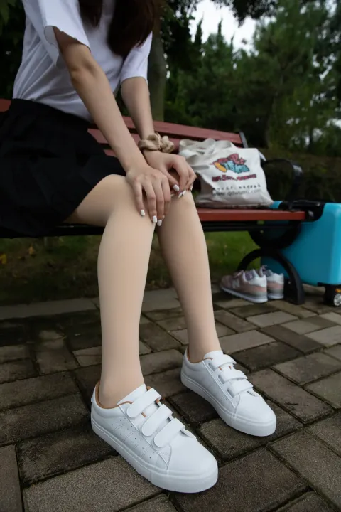 有个女人坐在长凳上，双腿交叉