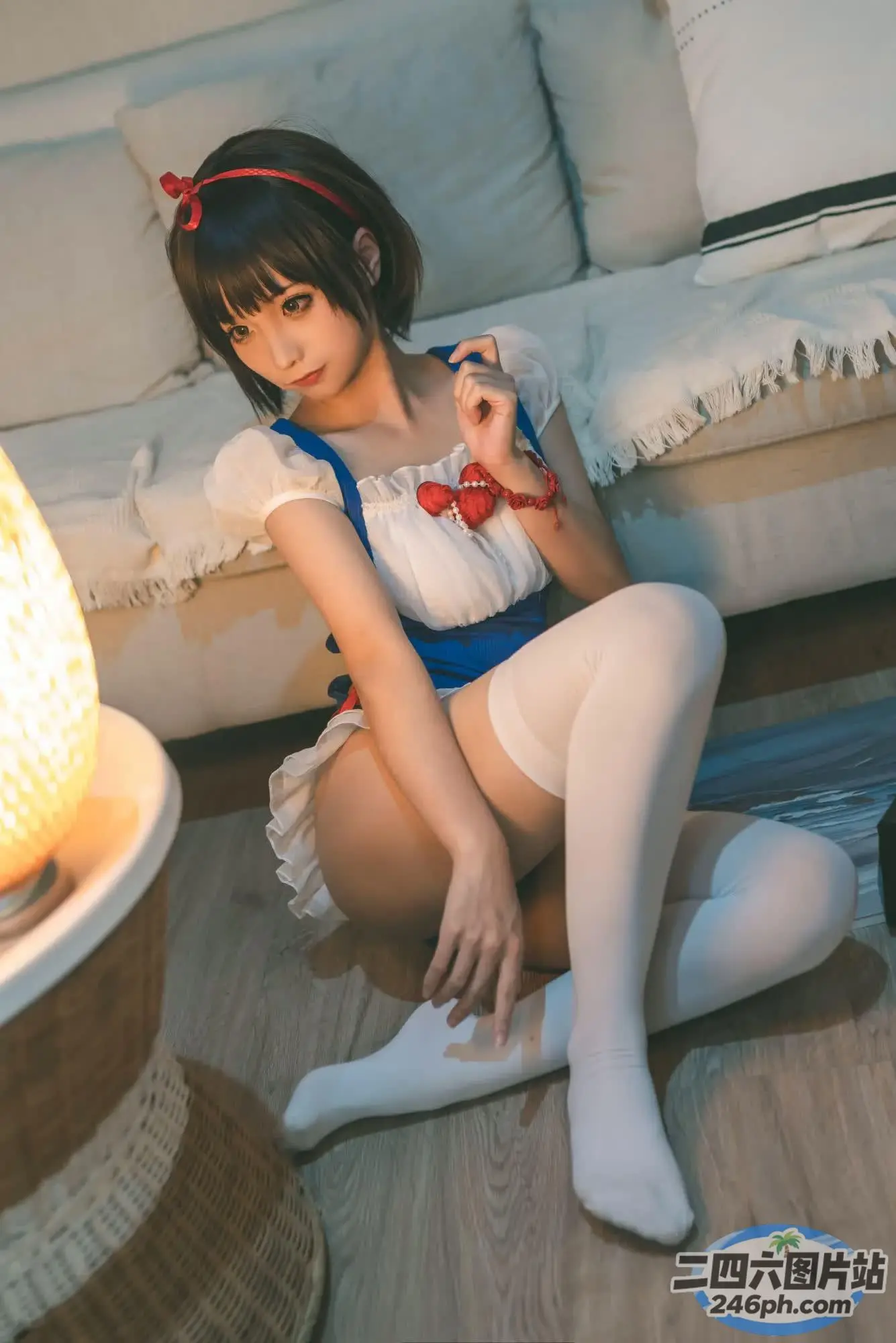地板上坐着一个女人，手里拿着一盏灯