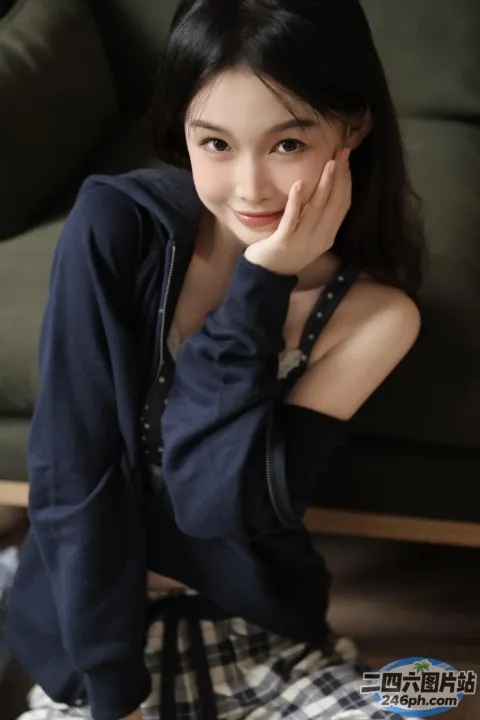 arafed 亚洲妇女坐在沙发上，手放在下巴上