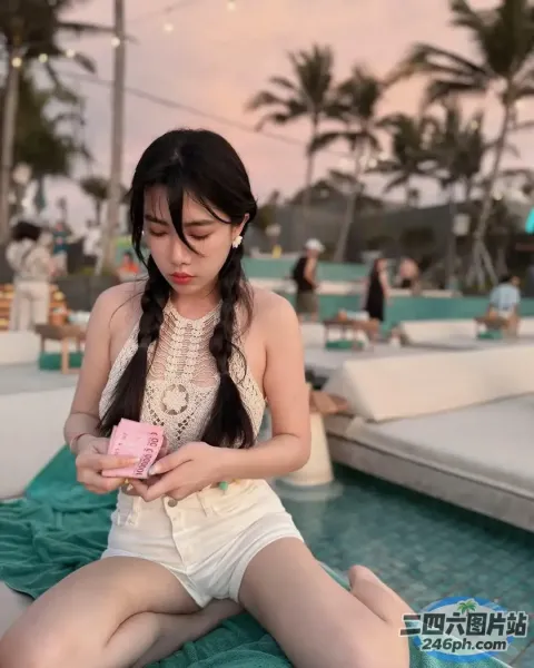 阿拉菲女子坐在毯子上，手里拿着一个粉红色的物体