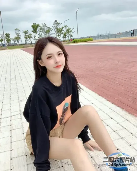 一名拿着滑板坐在砖砌走道上的女人
