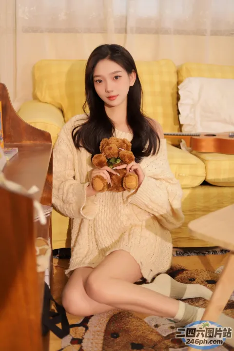 阿拉菲女人坐在地板上，手里拿着一只泰迪熊
