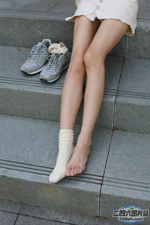 坐在台阶上的阿拉菲德女人，脚踩着一双鞋