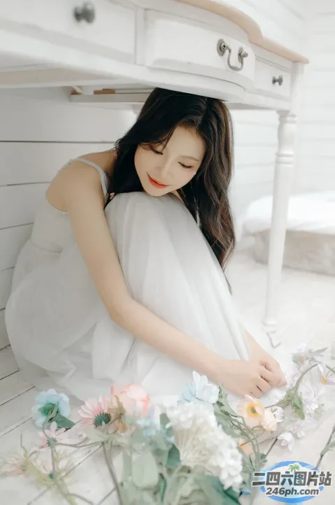 地板上坐着一个女人，周围插着鲜花