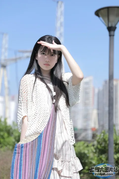 站在灯柱前的 Araffe 女人拿着钱包和手提包