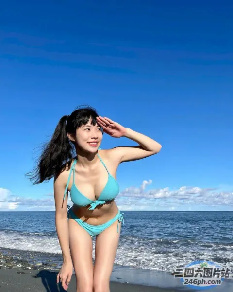 穿着蓝色比基尼的 arafed 女人站在海滩上