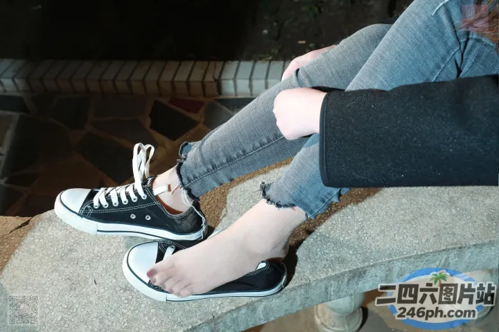 有人坐在长凳上，脚踩在石头上