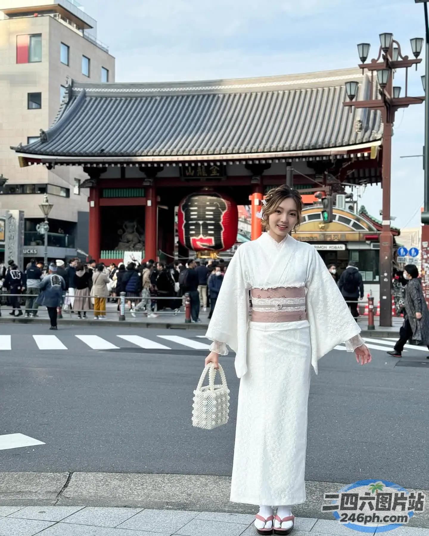 站在建筑物前街道上的白色和服女子