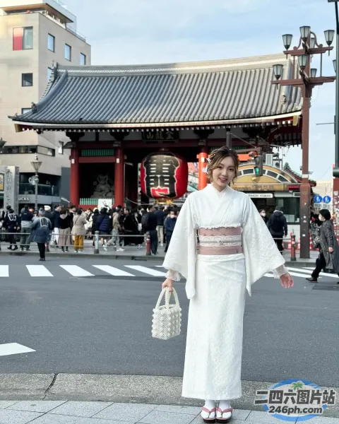 站在建筑物前街道上的白色和服女子