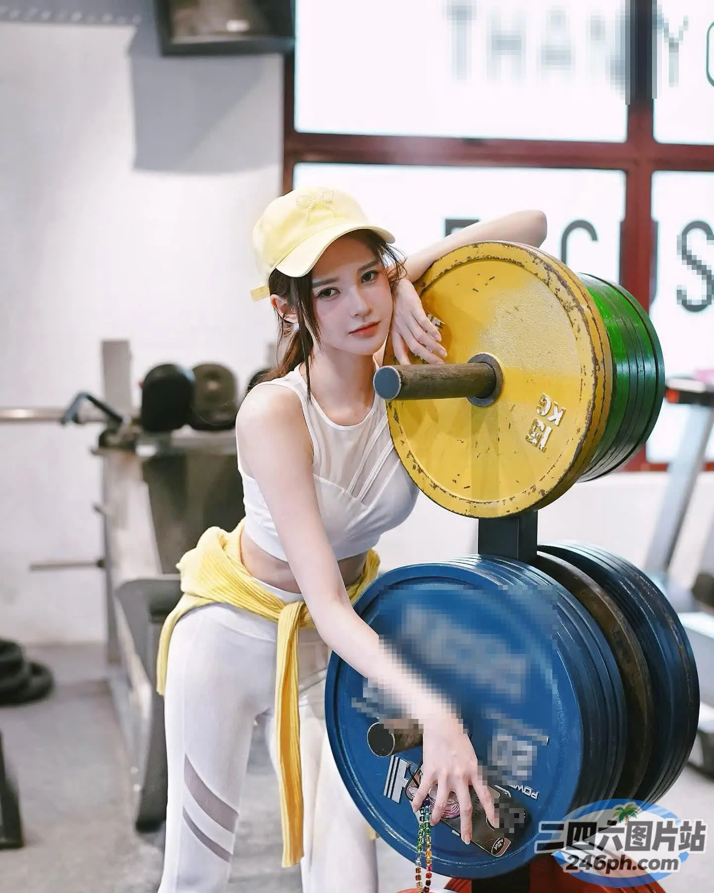 戴着黄色帽子的 Araffe 女士正在举杠铃