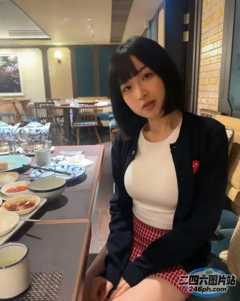 有一位女士坐在桌旁，桌上摆满了食物