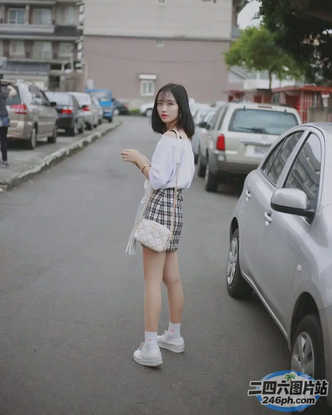 街上站着一个女人，手里拿着钱包