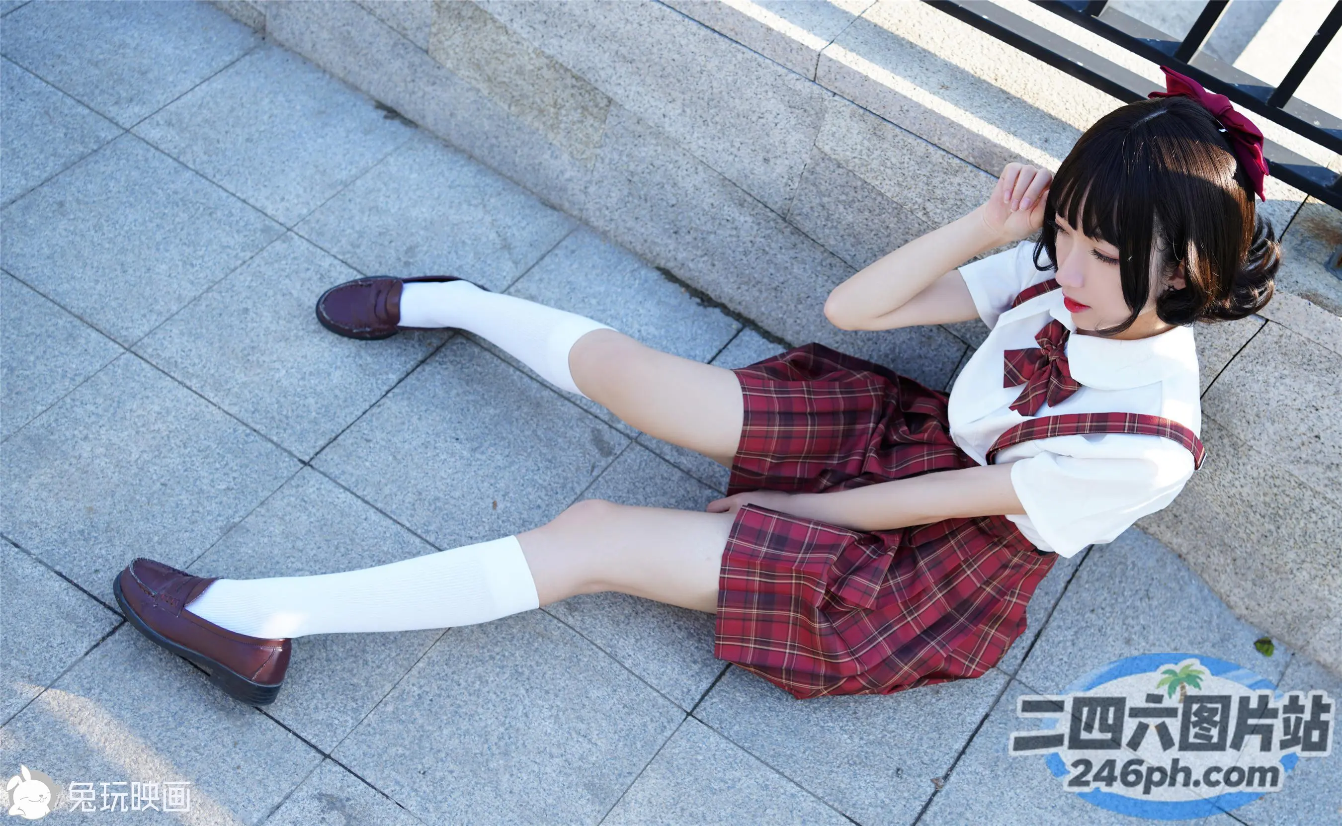 地上坐着一个穿着校服的年轻女孩
