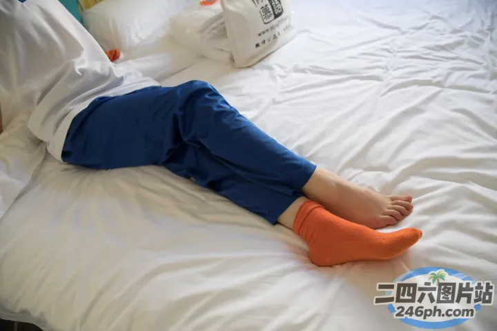有一个人躺在床上，手里拿着一双袜子