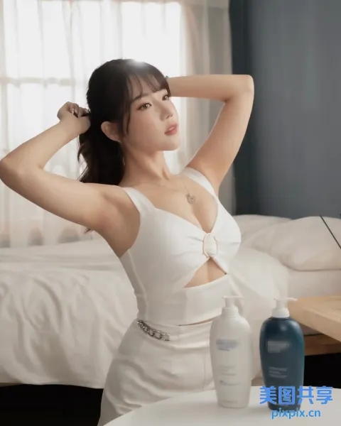 一个穿着白色连衣裙的女人坐在床上的特写