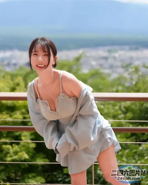身穿灰色连衣裙的 Araffe 女子在阳台上摆姿势