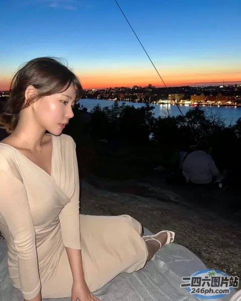 有个女人坐在毯子上看着笔记本电脑