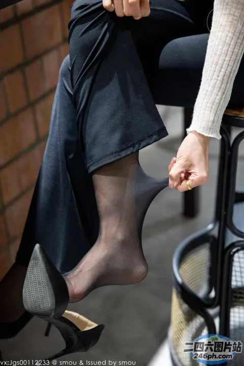 有人坐在椅子上，双脚抬起，一个人拿着一只鞋