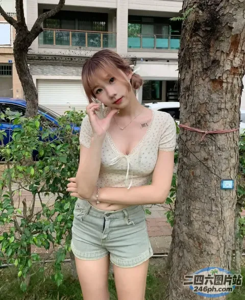 站在树旁的 Araffe 女子用手机说话