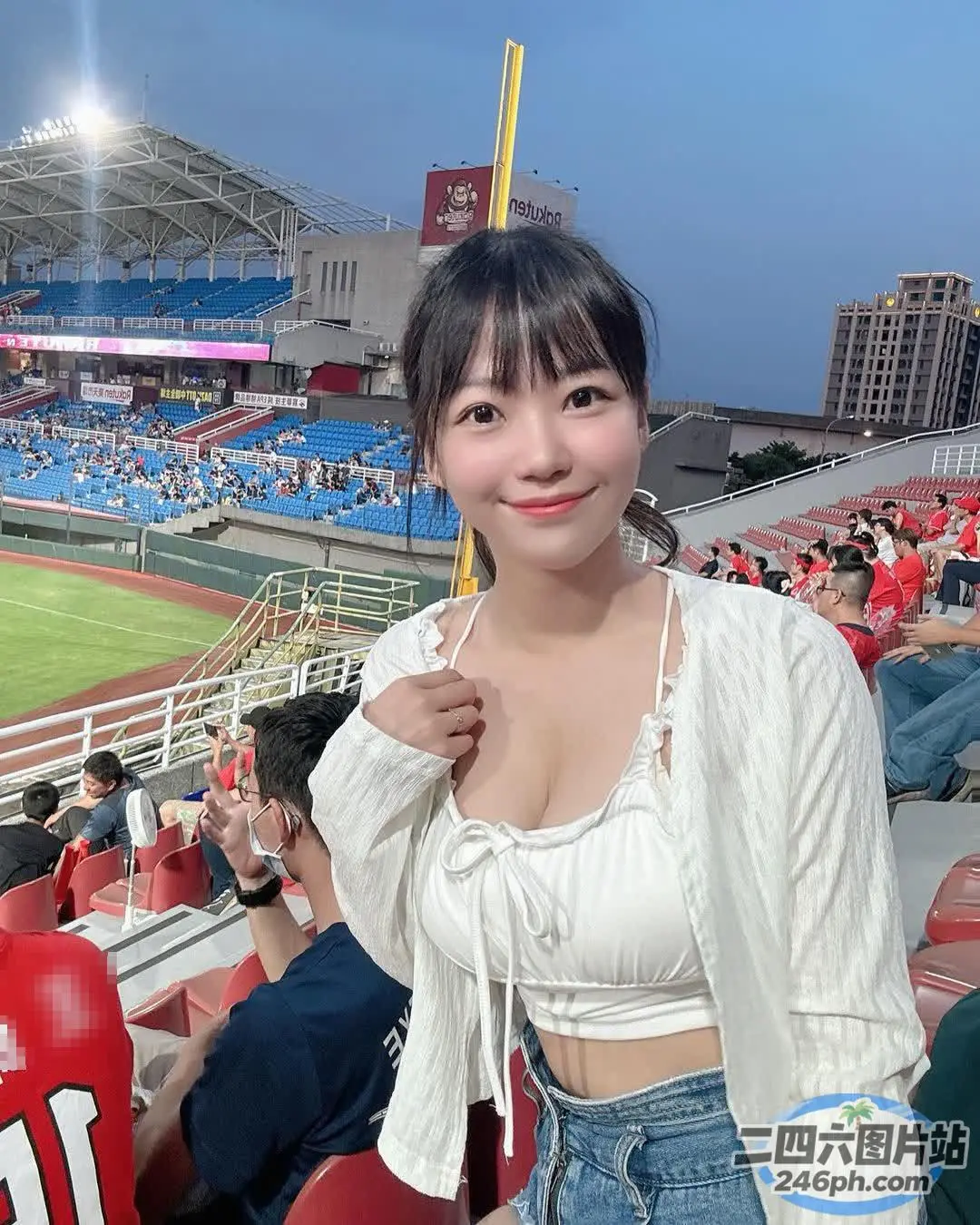 身穿白色上衣和牛仔裤的 Araffed 亚洲女性合影留念