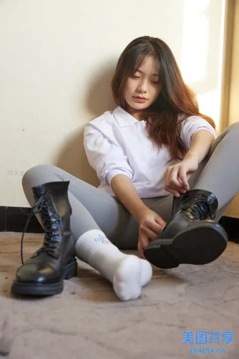阿拉菲女子坐在地板上，双叉，穿着鞋子