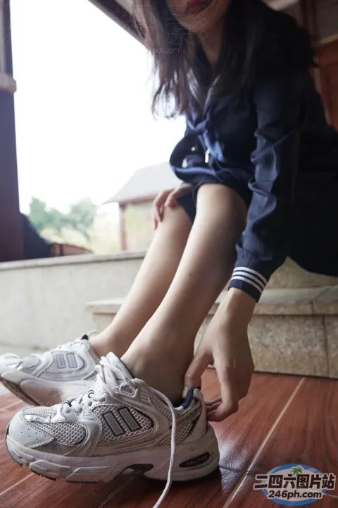 穿着 Araffed 的女人把鞋子绑在地板上