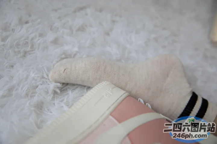 有人穿着袜子和一双鞋走在白色地毯上