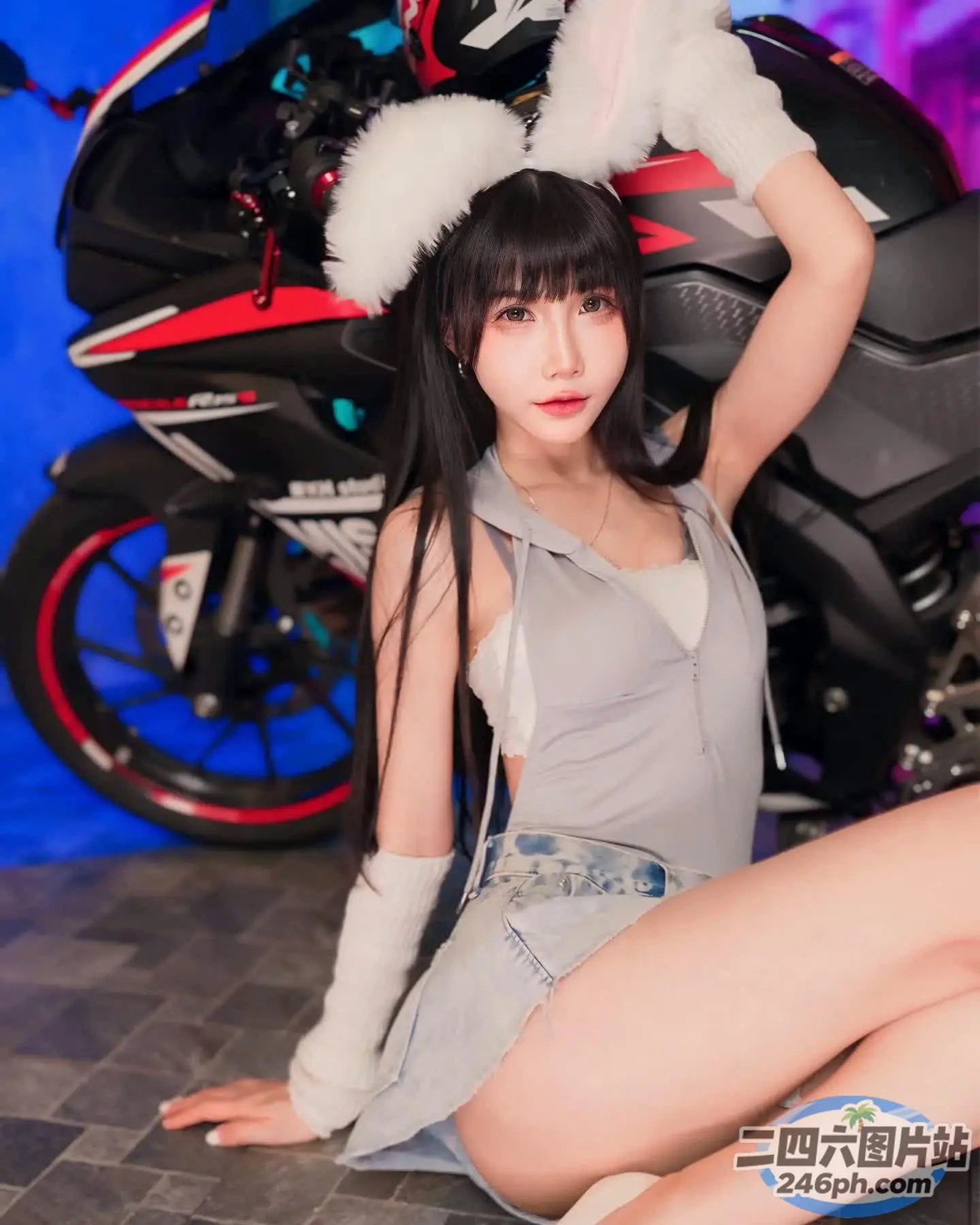 坐在摩托车旁边的地上的阿拉菲女孩