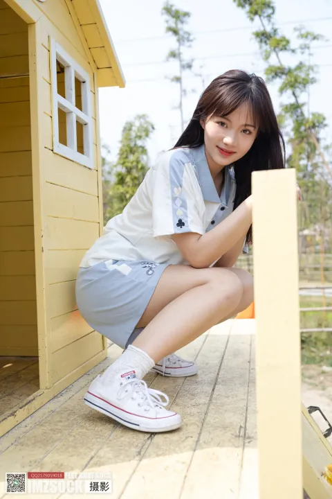 蹲在有狗屋的门廊上的阿拉菲女孩
