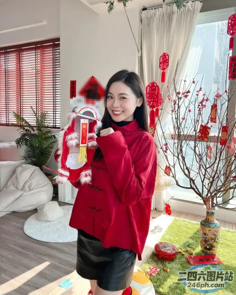 身穿红色夹克的女子手里拿着红白相间的毛绒玩具