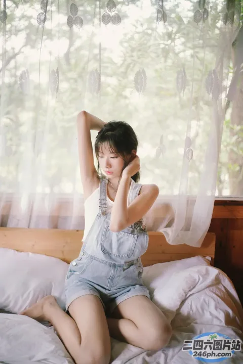 有一个女人坐在一张床上，床上有一个白色的枕头