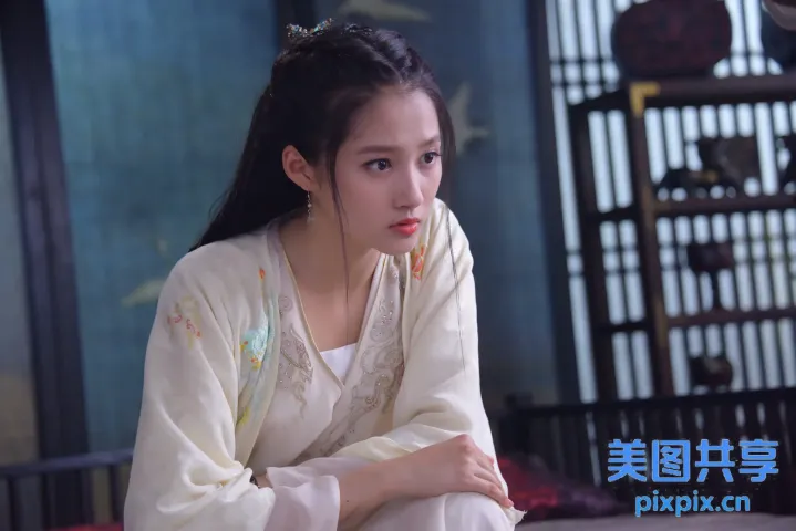坐在床上的身穿白色连衣裙的阿拉夫女人