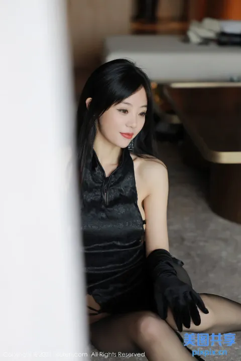地板上坐着一个戴着黑色手套的女人