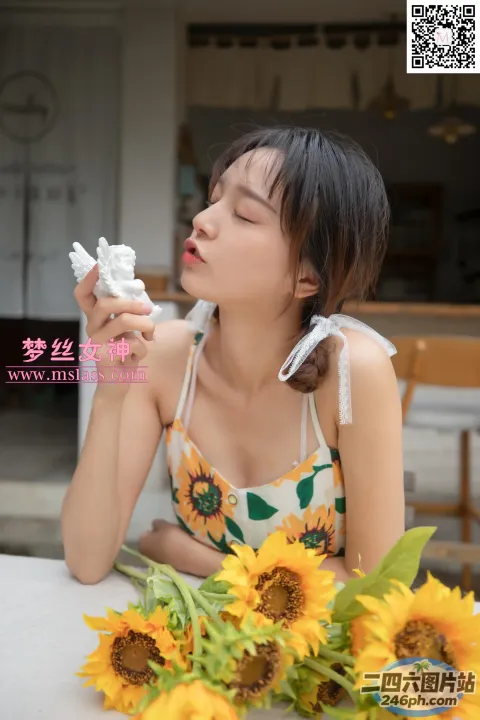 一位身穿比基尼上衣的女士坐在摆满向日葵的桌子旁