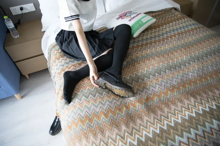 床上坐着一个女人，手里拿着一双鞋