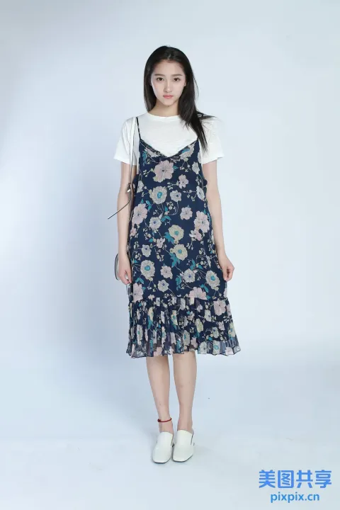 身穿碎花裙和白衬衫的 arafed 女子合影留念