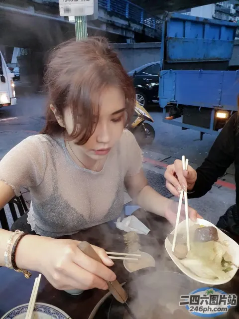 女人在桌子上用筷子吃一碗汤